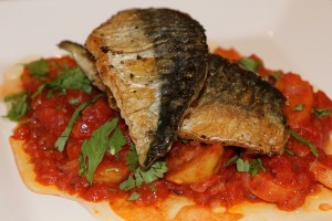 photo of Mackerel, sautéed potatoes and a warm tomato salsa in a white bowl