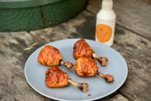 photo of Chicken Lollipops on a plate next to a bottle of BBQ sauce