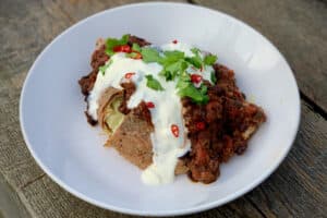photo of Mushroom chilli in a white bowl topped with sour cream