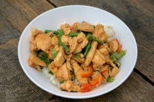 photo of Thai Red Chicken Curry on a bed of rice in a white bowl
