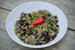 photo of Rice and Peas in a white bowl with a scotch bonnet chilli garnish