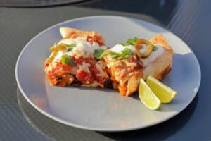 photo of Squash and Black Bean Enchiladas on a plate next to the bbq