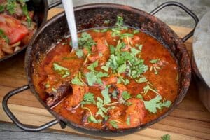 photos of a bowl of Chicken Tikka Madras on a board