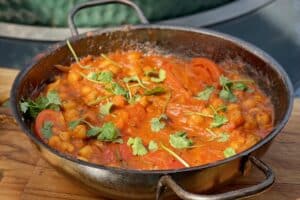 photo of Chana Masala in a balti bowl next to a bbq