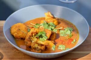 phot of a bowl of Staff curry on a table in the sun