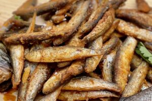 photo of lots of pan fried whitebait on a board
