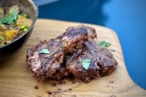 photo of several sweet and spicy goat chops on a board
