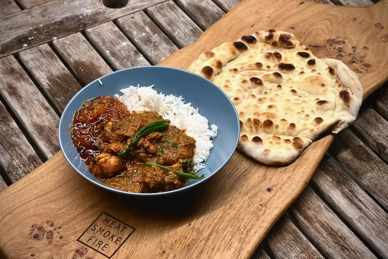 photo of Curry and naan on a slather board