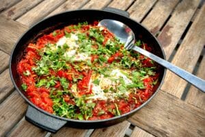 phot of cooked Shakshuka in a cast iron skillet on a table