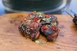 photo of Sweet and sticky Asian Chicken Thighs garnished with chilli