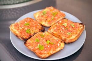 Picture of plate of Pane Con Tomate next to a bbq