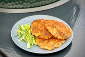 photo of three Crispy Rice Cakes on a small grey plate with a garnish of spring onions