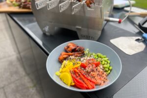 photo of a Korean Chicken Poke Bowl next to a Skotti Grill