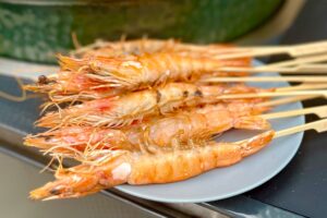 Prawn Skewers with Vietnamese Green Seafood Sauce on a plate next to the bbq