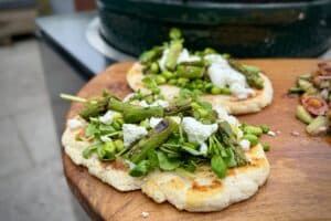 photo of pea, edamame, and asparagus flat breads on a board