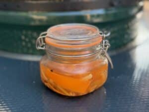 photo of a kilner jar of Pickled Carrots in front of a bbq